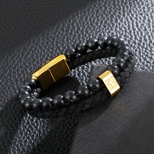 Macro view of double-layer men's leather bracelet with black stone beads and golden cross