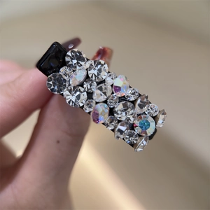 Détail d'une pince à cheveux à strass étincelants avec cristaux sur base noire