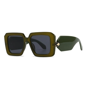 Green oversized square baroque sunglasses with golden serpent detail on white backdrop