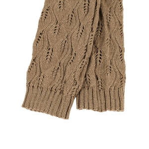 Close-up of brown knit leg warmers with hollow leaf pattern and ribbed cuffs