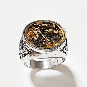 Detail of vintage silver and gold two-tone ring featuring a St. George and the Dragon relief
