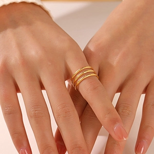 Dreilagiger 18K vergoldeter Edelstahlring mit gehämmerter Textur an einem Modellfinger