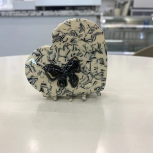 Elegant heart-shaped acetate hair claw clip with black ribbon bow in marble pattern