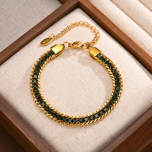Detail of 18K gold plated Cuban chain bracelet featuring inlaid green zircons and K18 stamp