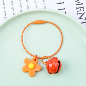 Detail of DIY floral keychain with orange wire ring, yellow flower and red bell charm