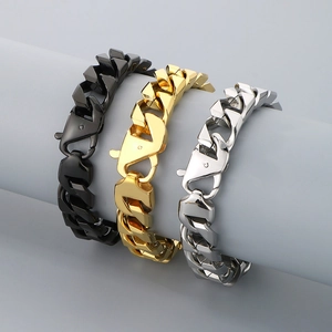 Polished stainless steel Cuban link bracelets in black, gold, and silver on display stand