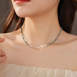 Detail of beaded choker necklace featuring teal stones and silver metallic cubes