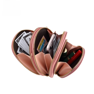 Detail view of pink crossbody wallet with three zipper compartments and card slots