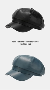 Detail of PU leather newsboy caps in black and dark cyan with multi-panel stitching