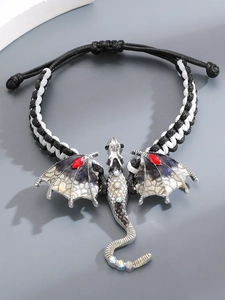 Detail van een gevlochten armband met zilveren draak, kleurrijke stenen en rode inlays