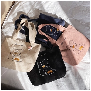 Flat lay of corduroy tote bags in four colors with cute bear embroidery detail