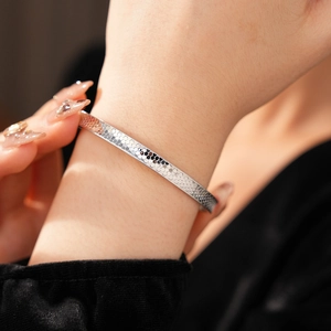 Macro shot of silver textured bangle showing detailed honeycomb patterns and polished finish