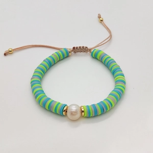 Detailed close-up of handmade beaded bracelet with colorful clay discs and natural pearl