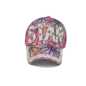 Detailed close-up of the STAR letter logo featuring faux pearls and rhinestones on the hat