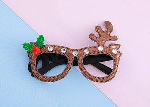 Détail de lunettes de Noël renne avec paillettes brunes, strass et pompon décoratif