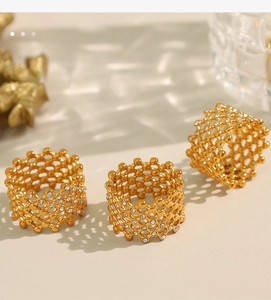 Macro shot of three gold-plated honeycomb rings with sparkling Czech crystals on a soft background