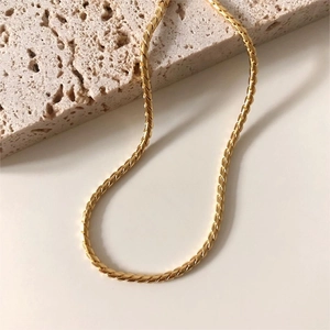 Macro shot of gold-plated S925 sterling silver snake chain texture on stone surface
