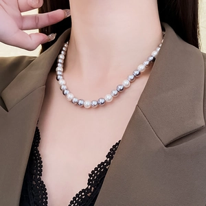Close-up of white and silver pearl necklace worn by a model for elegant look