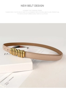 Close-up of beige leather belt with unique gold metal multi-ring buckle on magazine