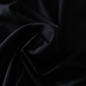 Détail macro de la texture du tissu noir et des plis volantés du haut court sexy