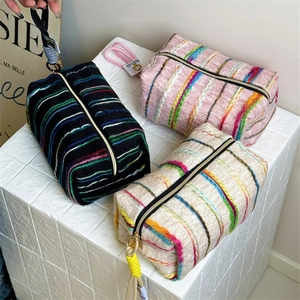 Close-up of woven bohemian cosmetic bags with colorful stripes and sturdy zipper pulls