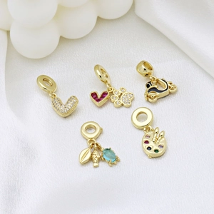 Five gold charms featuring heart, paw print, and shell designs for DIY bracelets