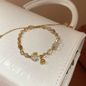 Detail of adjustable citrine beaded bracelet with golden lotus seed pod charm and cloud beads
