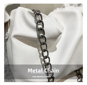 Detail view of the white cloud pleated handbag showing the gunmetal chain strap texture