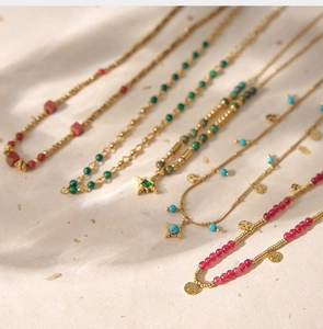 Flat lay of bohemian handmade crystal beaded necklaces with vintage gold chains and pendants