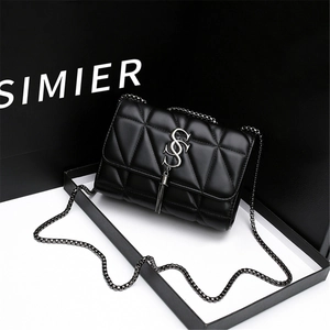 Detail of black quilted leather shoulder bag with silver metal tassel and logo