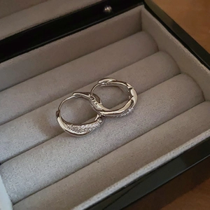 Detailed view of silver double-hoop earrings featuring micro-pave small diamonds
