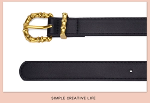 Close-up of black PU leather belt featuring a golden bamboo-shaped metal buckle design