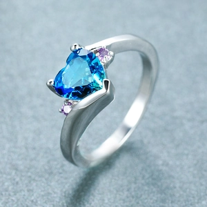 Elegant heart-shaped blue zircon ring with purple accents and curved silver band
