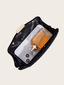 Detail view of the black sequined evening clutch showing interior capacity for a phone