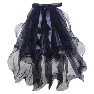 Detail of black multi-layer tulle veil with a satin bow knot decoration on white background