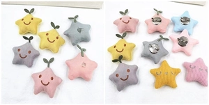 Detailed view of plush star brooch accessories in soft colors with embroidery and pin