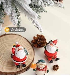 Detailed view of mini resin Santa and snowman figurines on a festive wooden surface