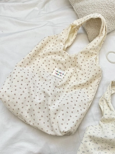 Corduroy tote bag in off-white with vintage floral print and brand label shown on fabric