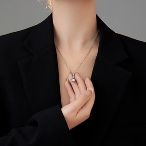 Collana con ciondolo a corona cuore in zircone colorato indossata su un blazer nero