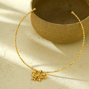 Elegant gold bow pendant necklace in polished stainless steel on a minimalist background