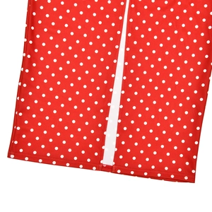 Detailed view of red polka dot dress hem with high-quality stitching and side slit detail