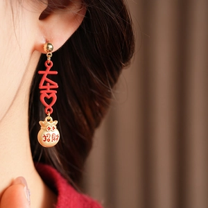 Detail of vintage red and gold dangle earrings with Xi character and lucky pouch charms