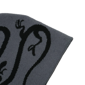 Close-up of premium dark grey knitted beanie with intricate black jacquard dragon pattern