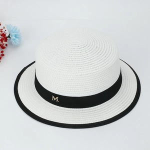 Détail du chapeau canotier blanc avec ruban noir et breloque lettre M dorée