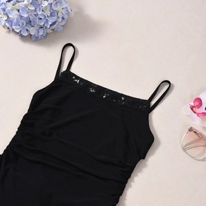 Detail of black strapless dress with sequin embellishment and pleated fabric texture