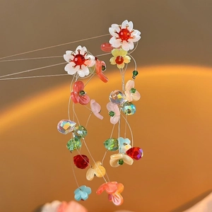 Detailed view of colorful handmade floral tassel earrings with acrylic beads and crystals
