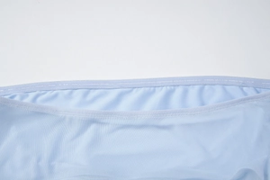 Close-up of light blue mesh fabric with breathable texture and precise stitching detail