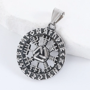 Detailed macro view of silver stainless steel Viking rune pendant on white stone base