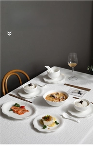 Detailed view of white ceramic dinnerware set featuring elegant embossed patterns