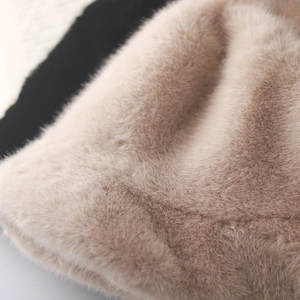 Detail of soft faux fur bucket hat fabric in beige and black, thick and plush texture
